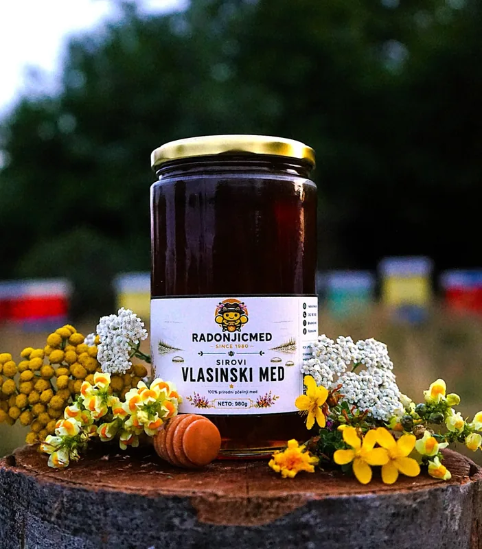 Tegla vlasinskog meda od 980 g na panju, uz poljsko cveće